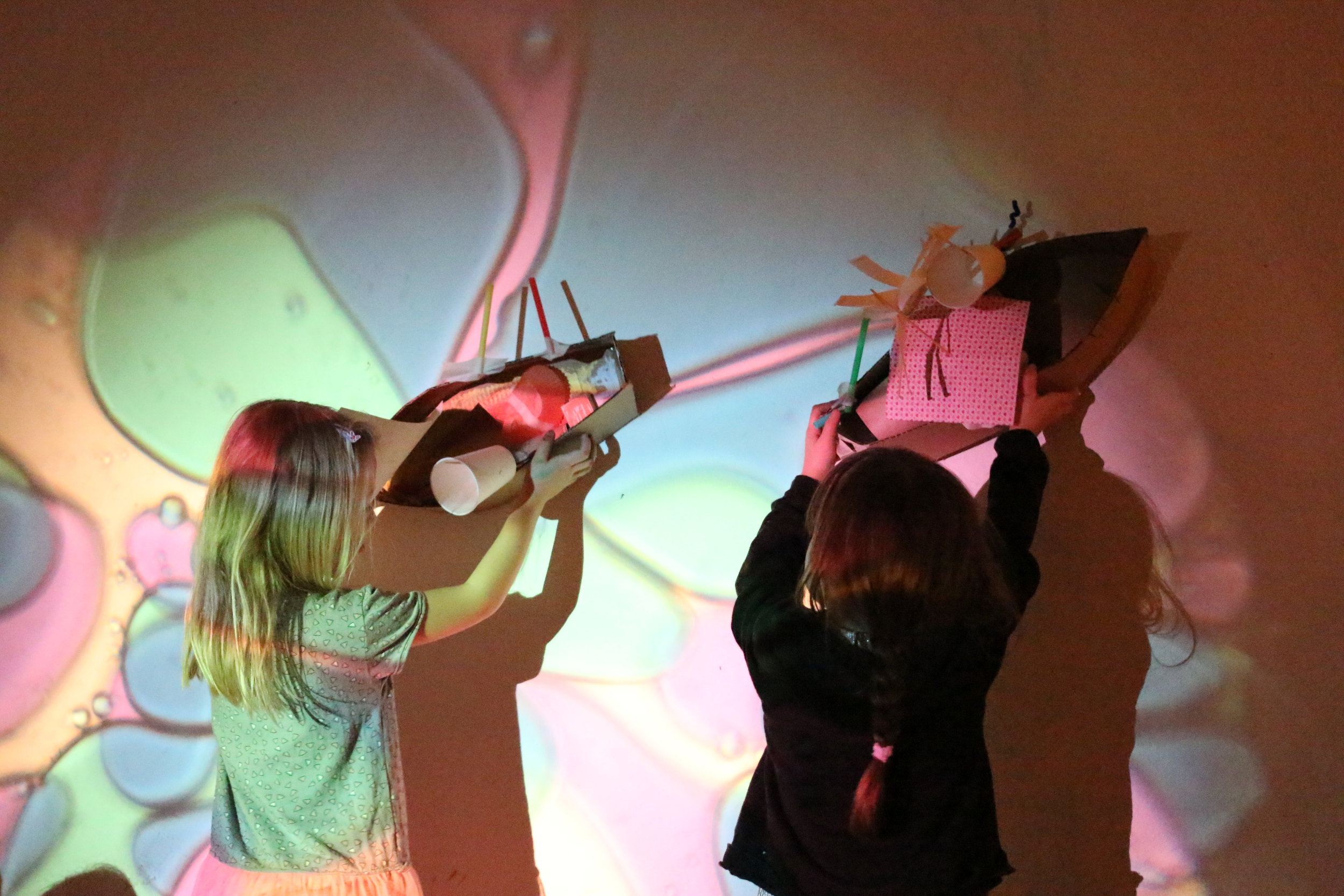 Kids engaging in creative play with crafting with junk and colourful projections