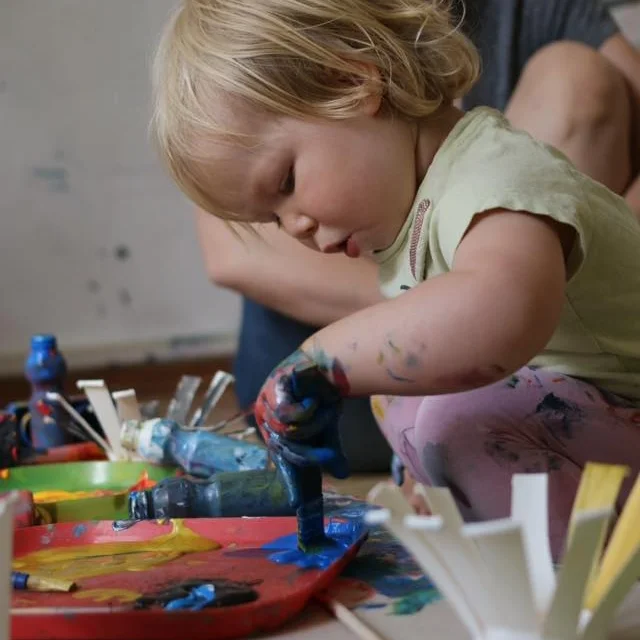 Child playing with paint and colour in a kids art workshop