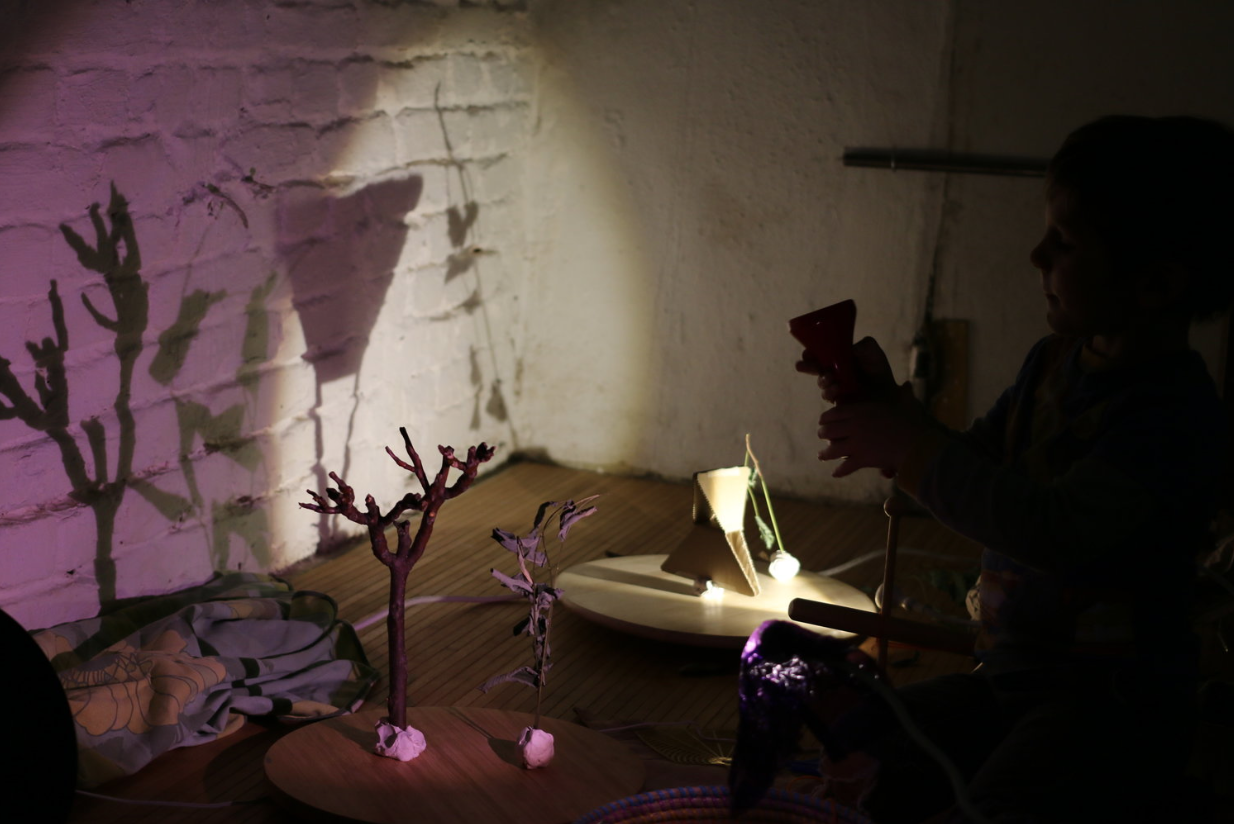 A child explores shadows in a sensory play art workshop