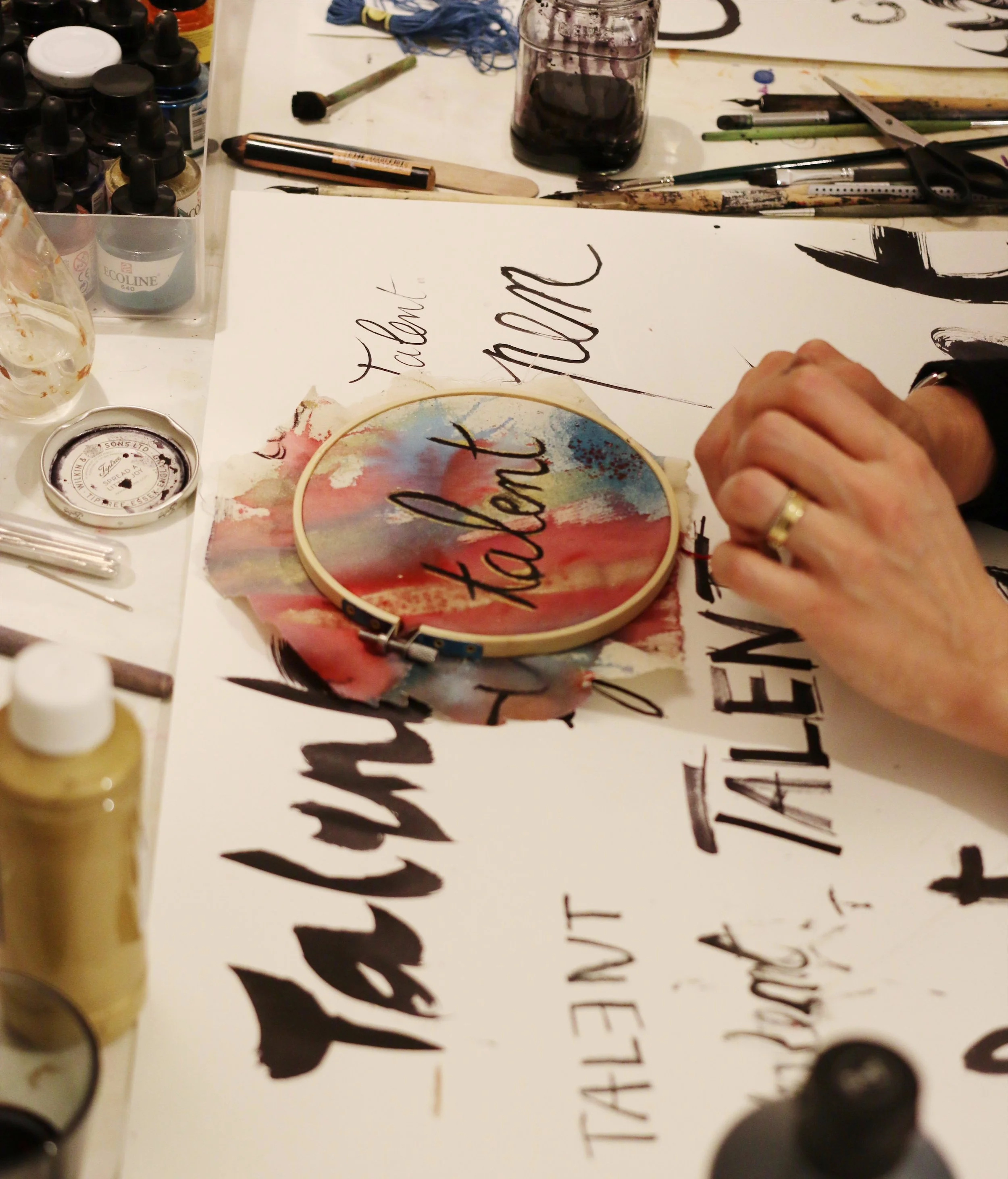 Ink lettering and hoop art being made by a female