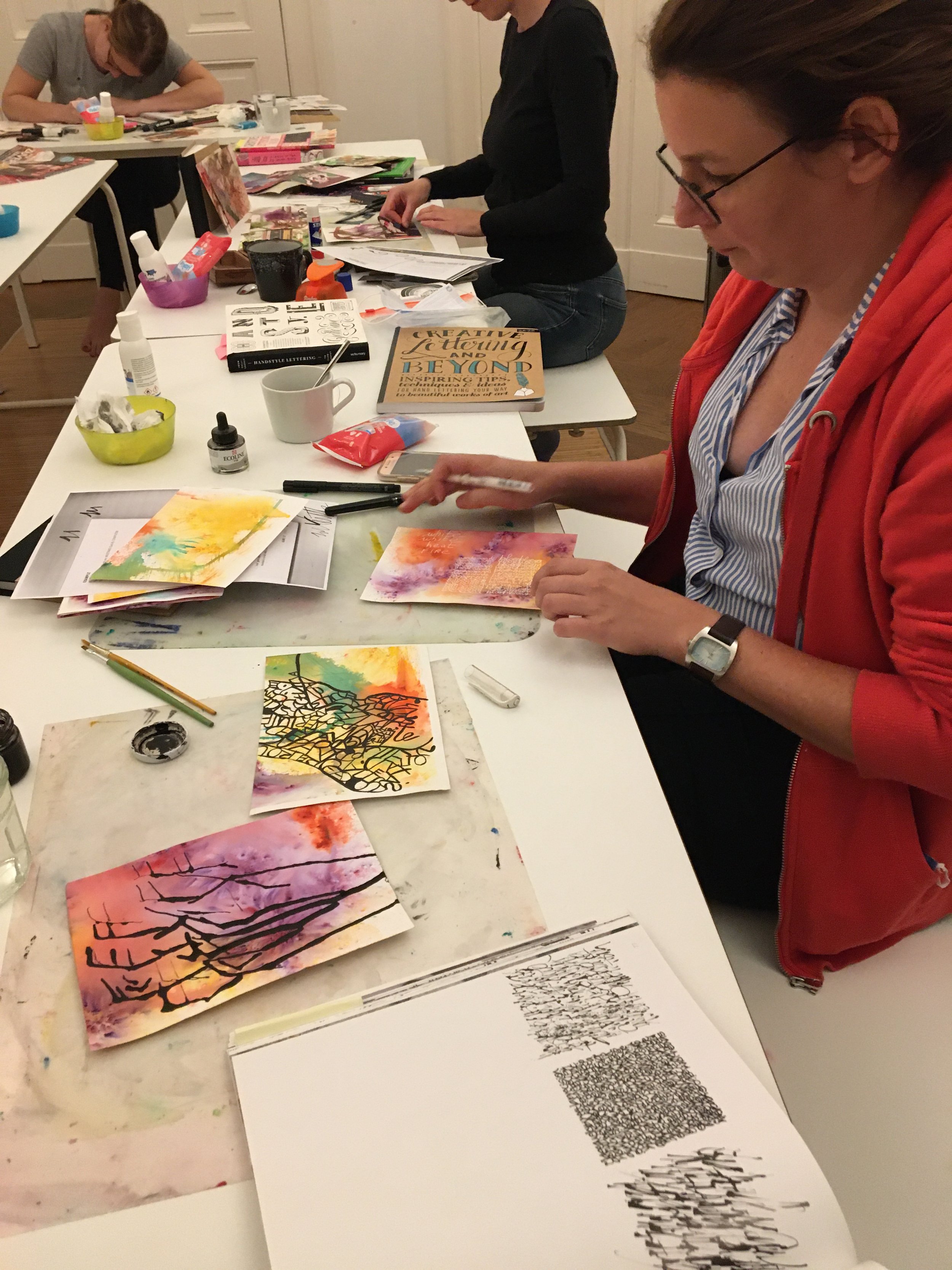 Person using ink and watercolour to make abstract art on paper