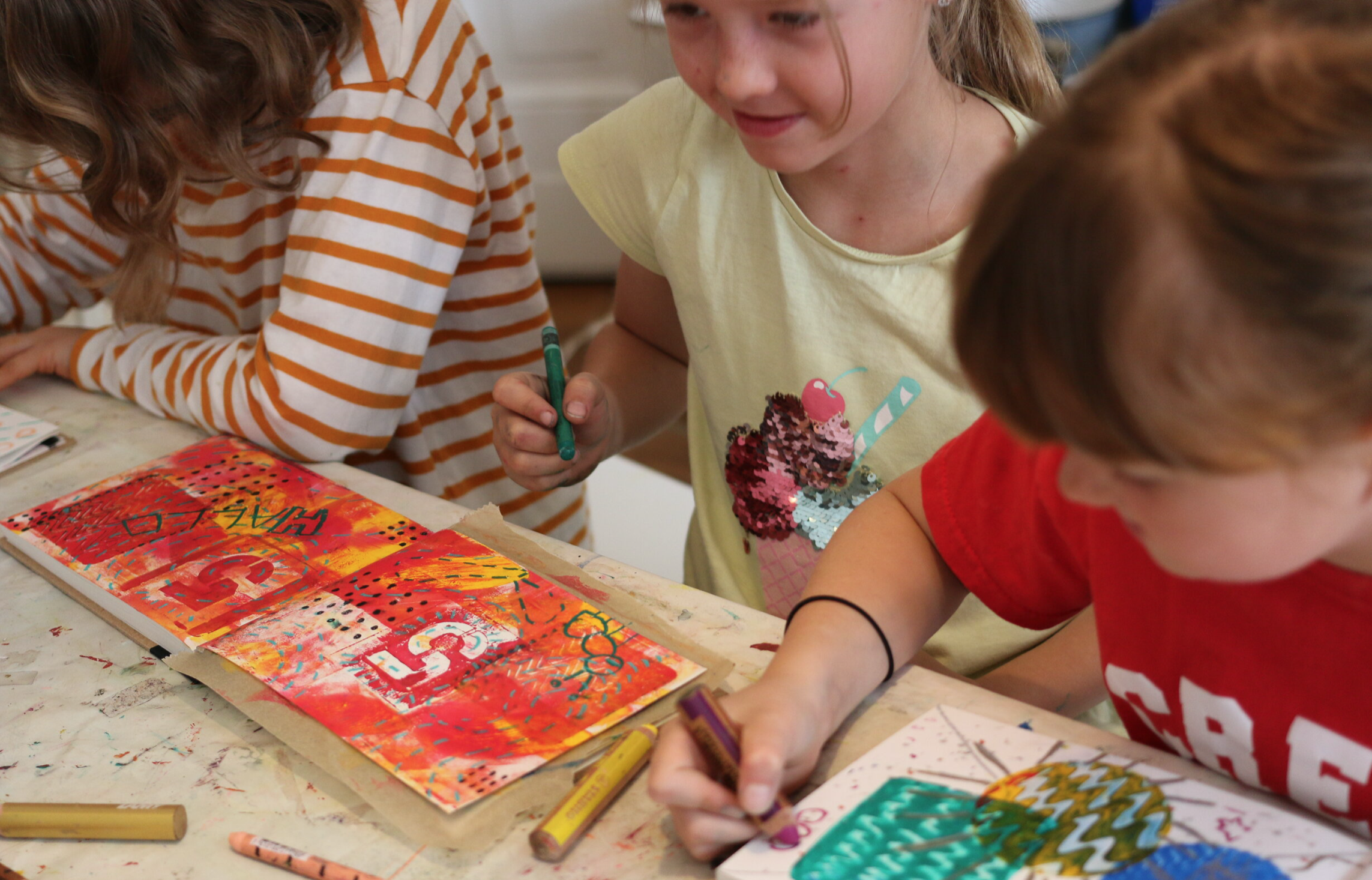Kids having fun doing art journalling with paint, pens, collage