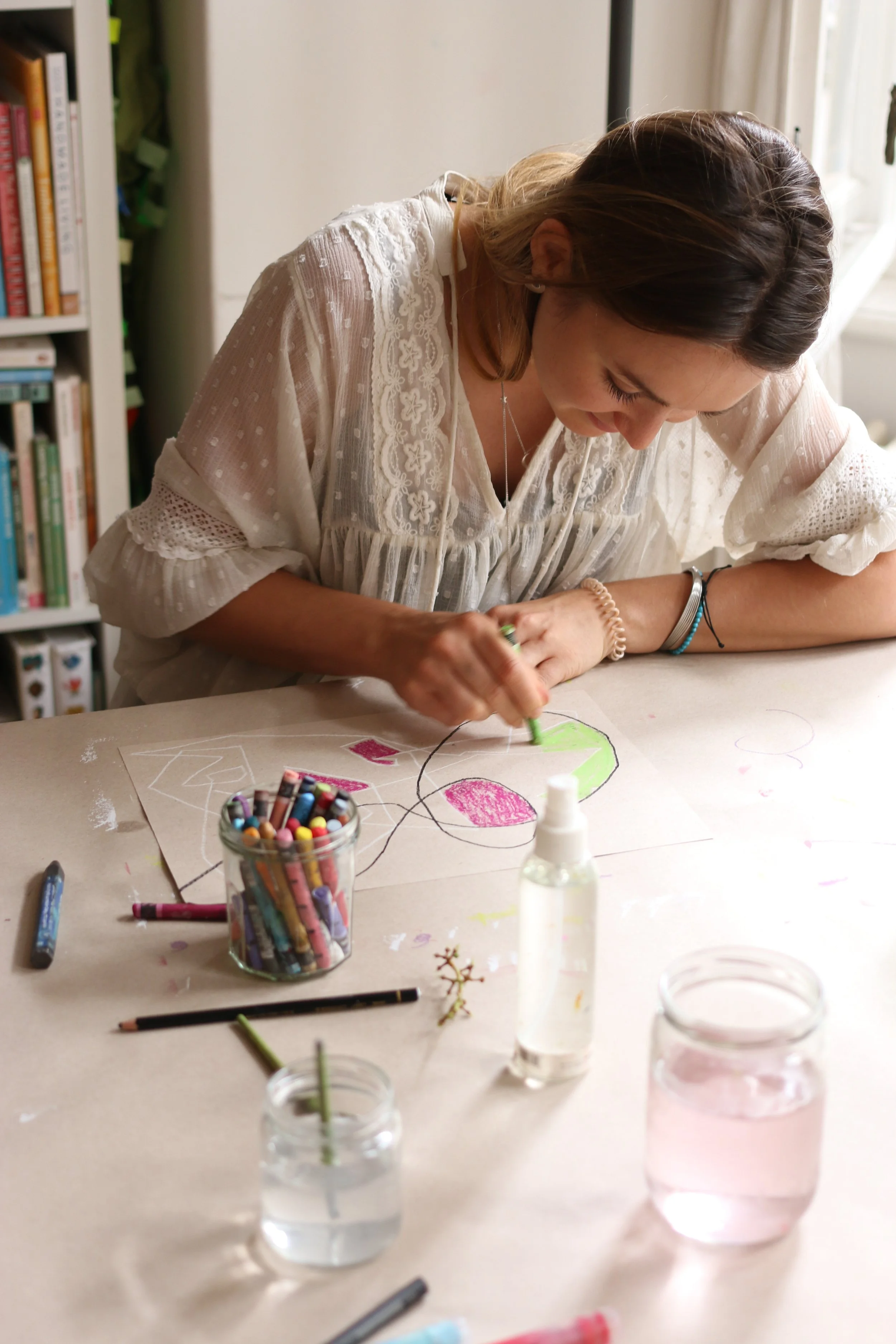 Relaxed female slowly making doodles using crayons