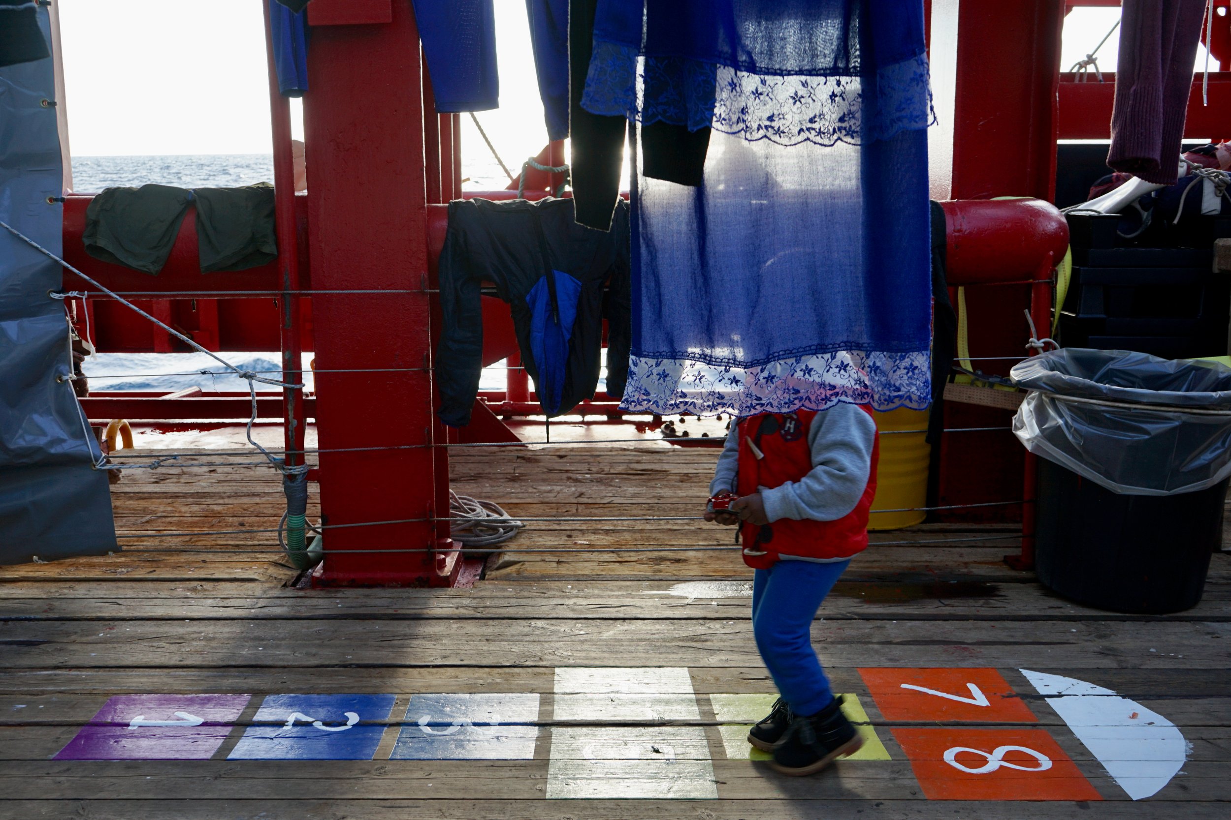 A young survivor walking on the deck of Ocean Viking. 