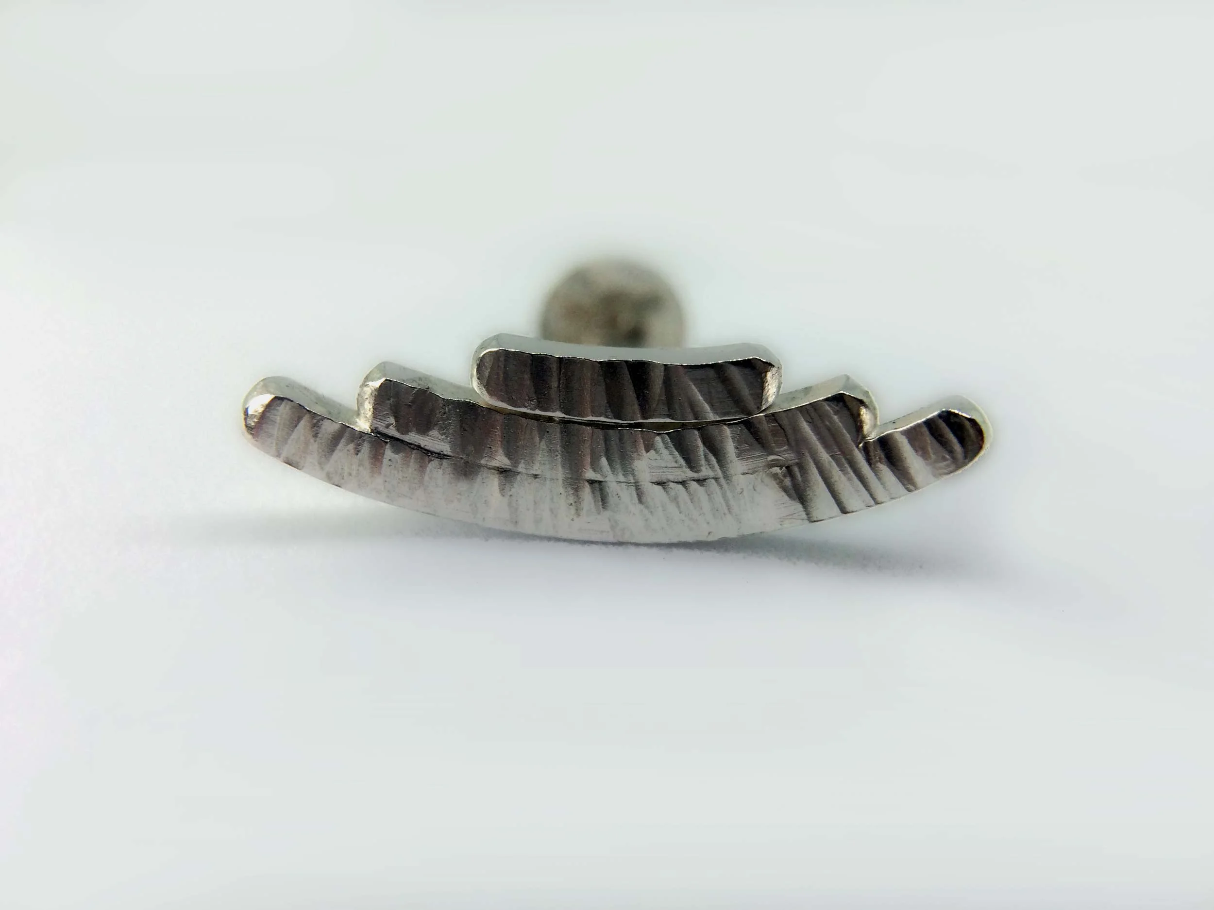 handmade silver conch piercing on white background