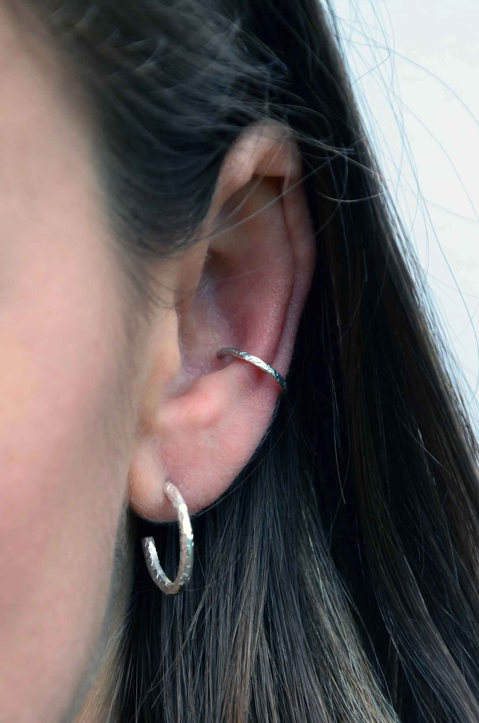Shiny recycled silver conch earring on model