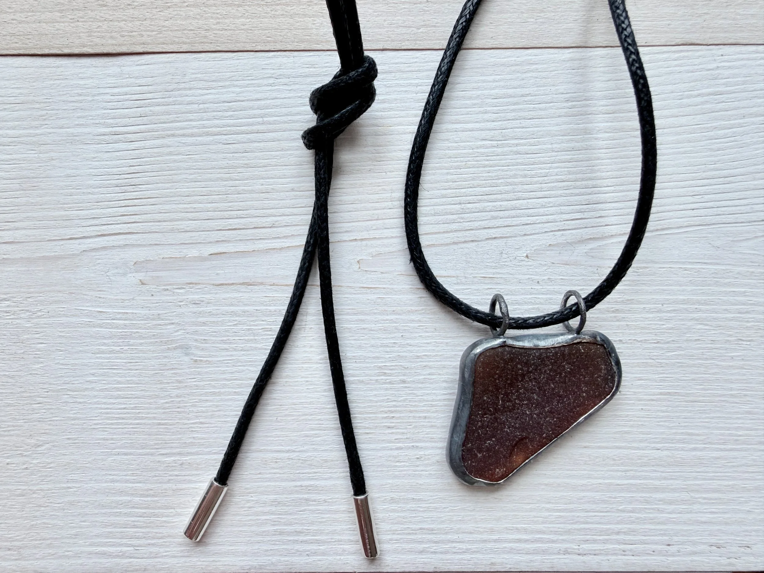 handcrafted coffee brown seaglass pendant on an adjustable length black cotton cord