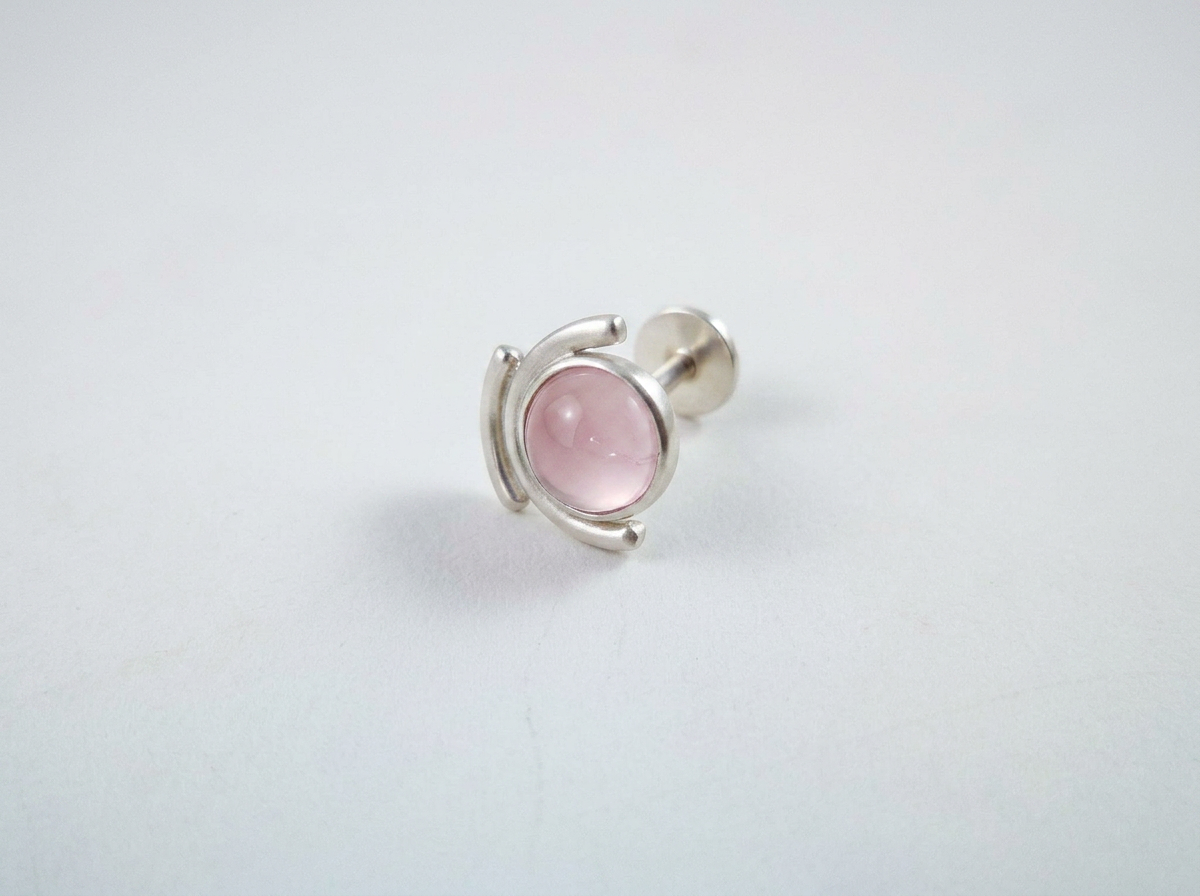 Handcrafted recycled sterling silver celestial rose quartz sun and moon conch stud earring on white background.