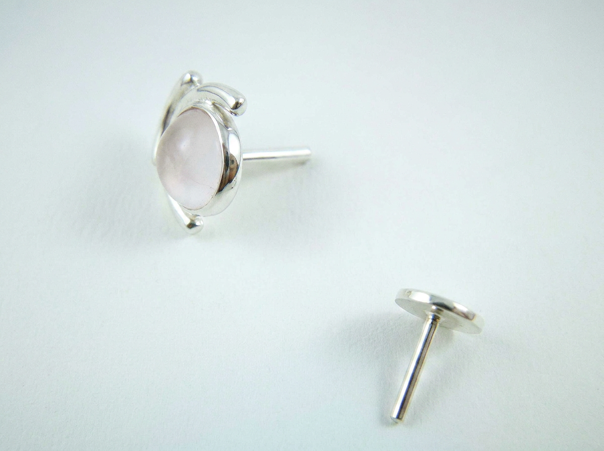 Macro close-up of rose quartz gemstone embraced by abstract silver moons with threadless flat back labret post.