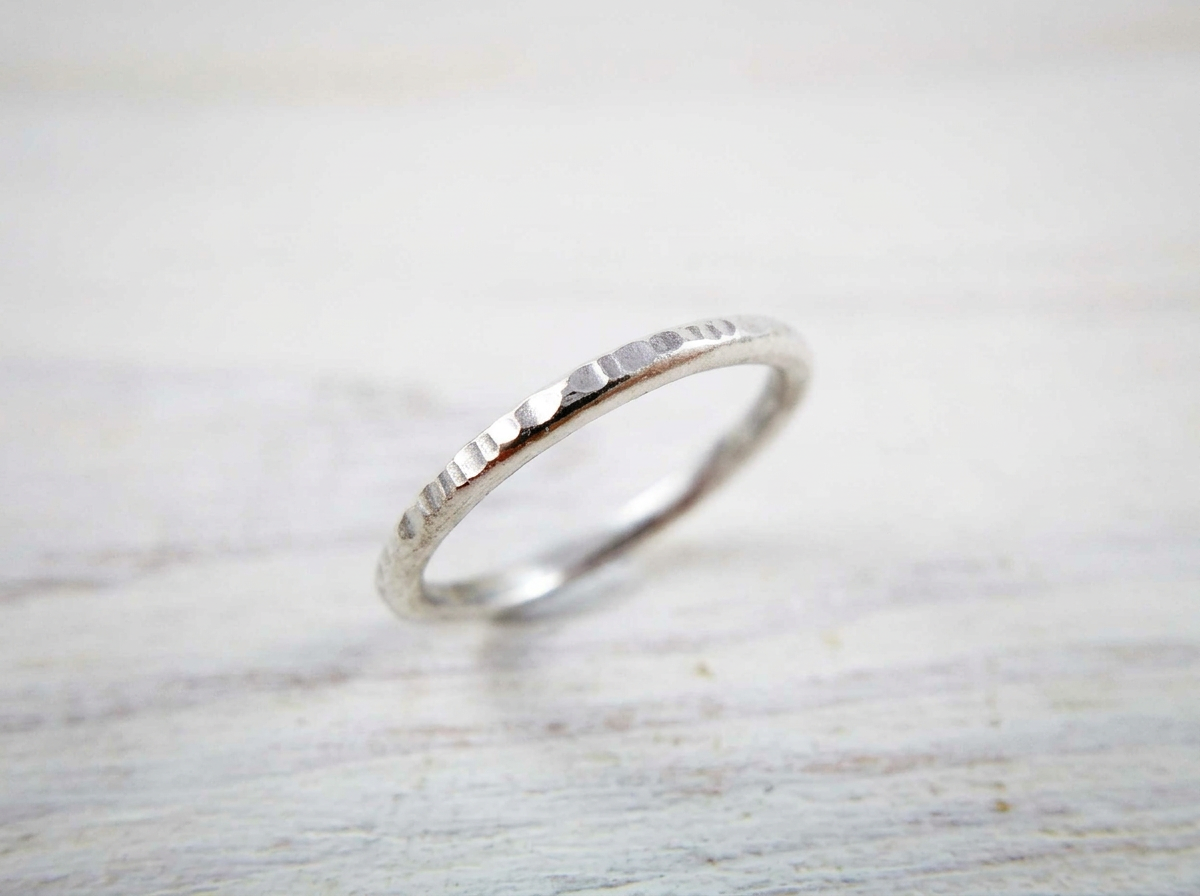 handmade recycled silver line hammered conch hoop earring on a white wood background