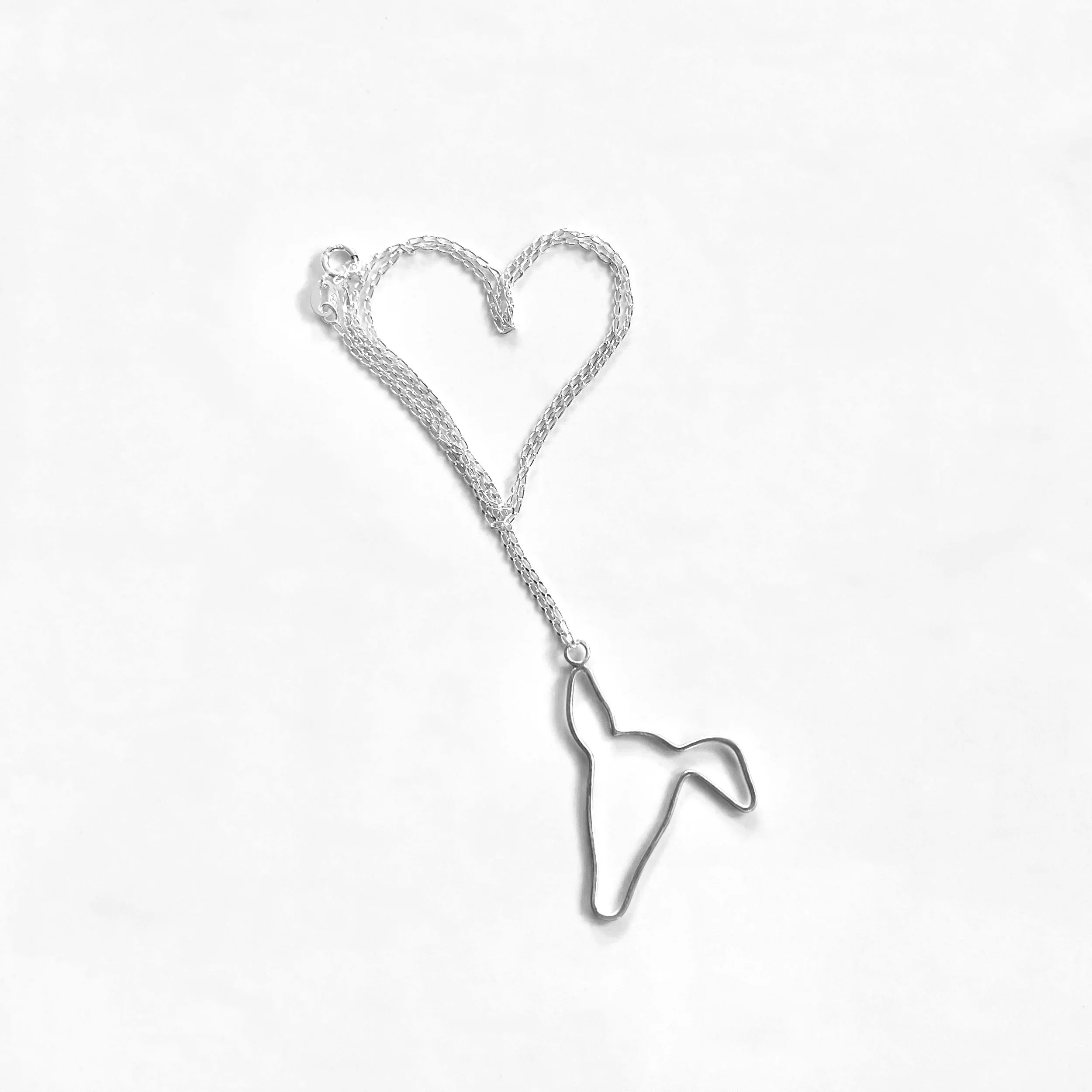 Handcrafted recycled sterling silver greyhound silhouette pendant with a brushed satin finish on a silver chain curved into a heart shape