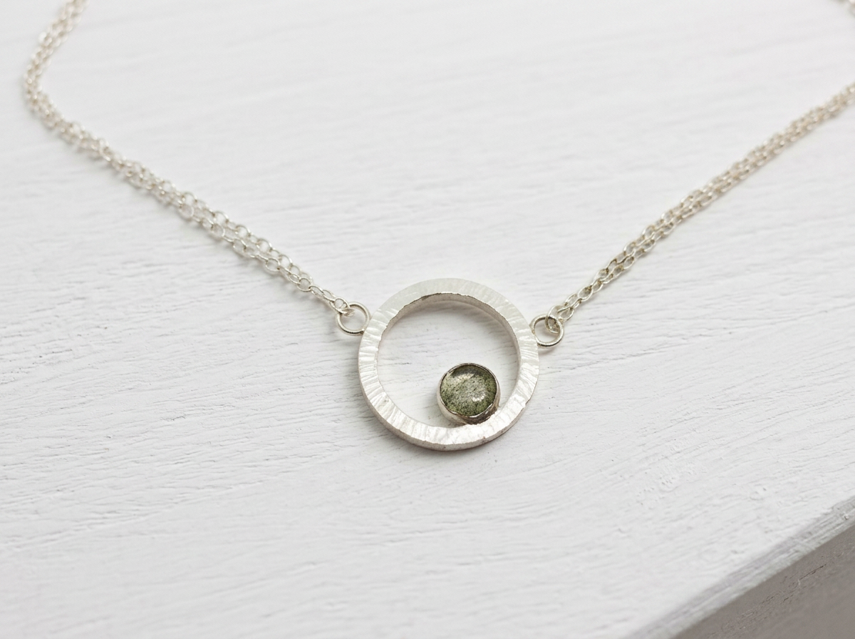 Hammered recycled sterling silver circle necklace with bezel-set labradorite stone on doubled silver chain.
