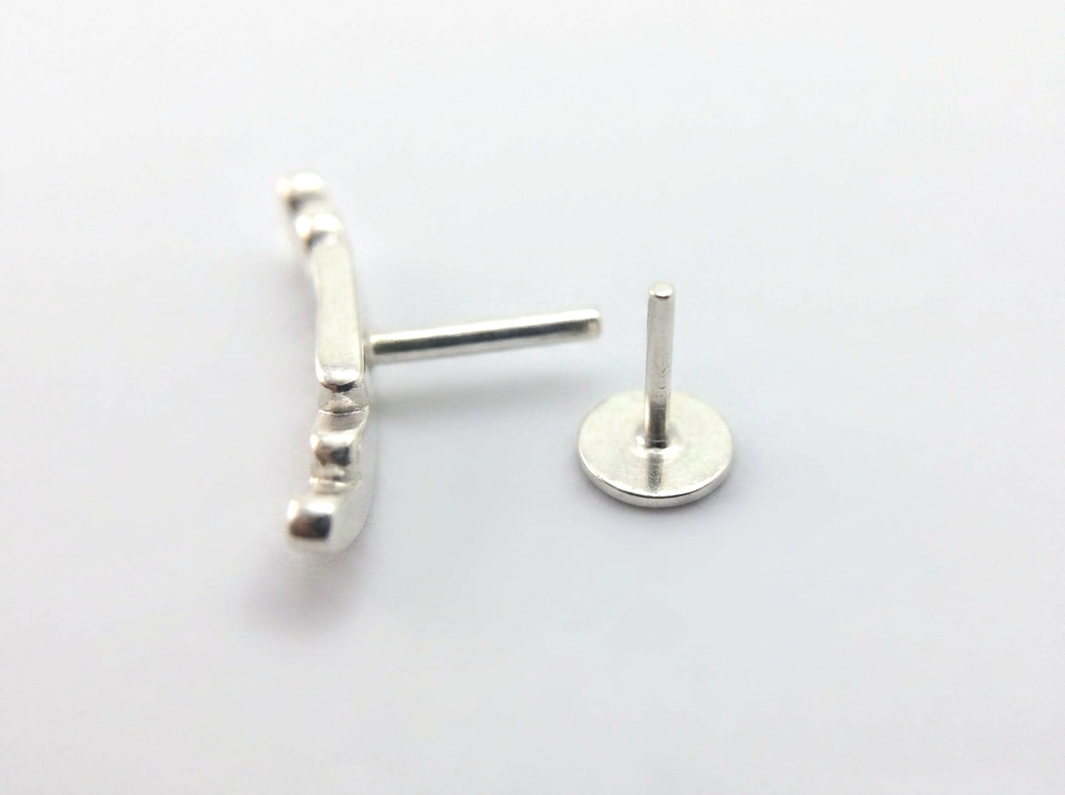 handmade curved conch earring with a threadless press fit 16g post on a white background