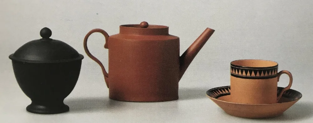 Group of Wedgwood Dry Body Teawares. From left: black basalt sugar bowl, 1874; red stoneware teapot 1931, stoneware tea bowl and saucer, 1947