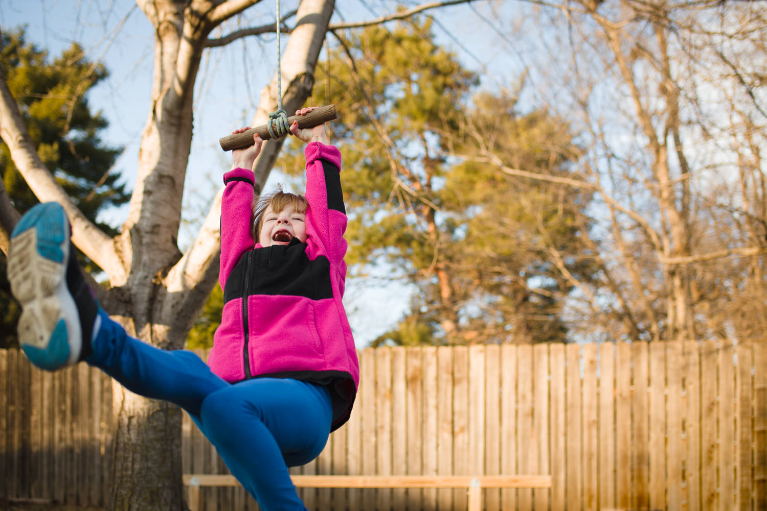 girl in pink jacket on a tree rope swing in my backyard, Lincoln, Nebraska