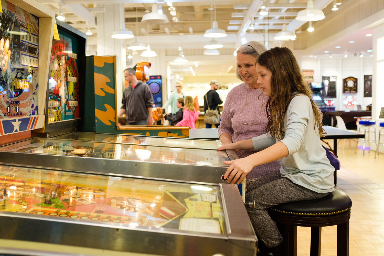 girl playing pinball