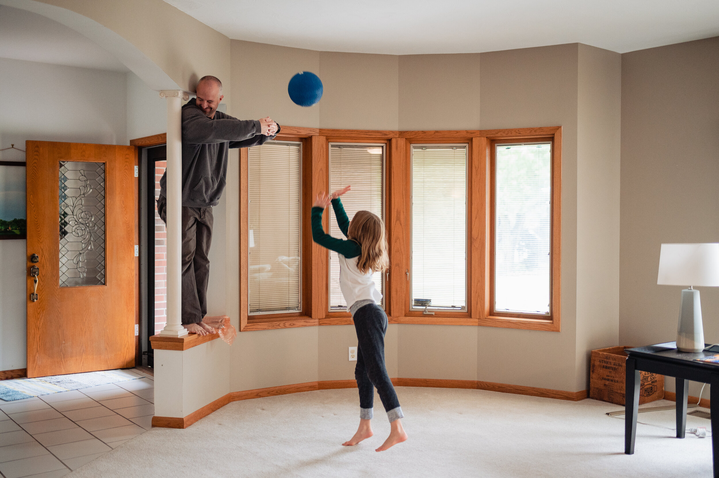 girl playing basketball with her dad indoors.jpg