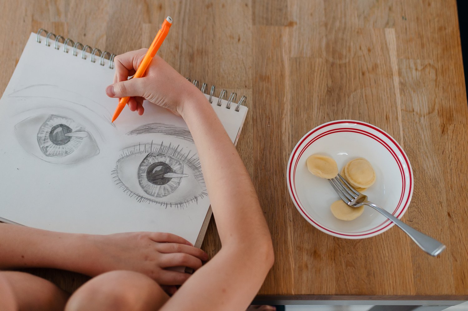girl sketching eyes on a table with noodles.jpg