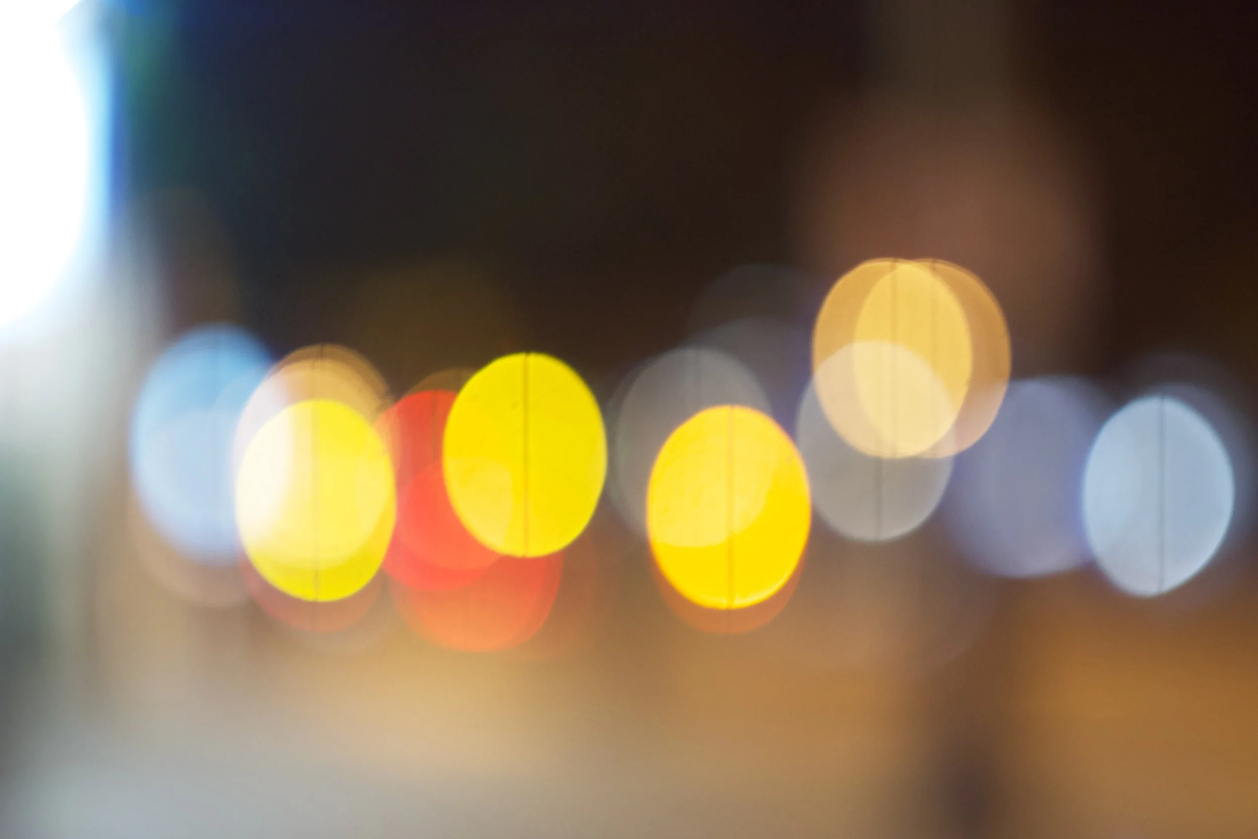Blurred city street at night with colorful bokeh lights.