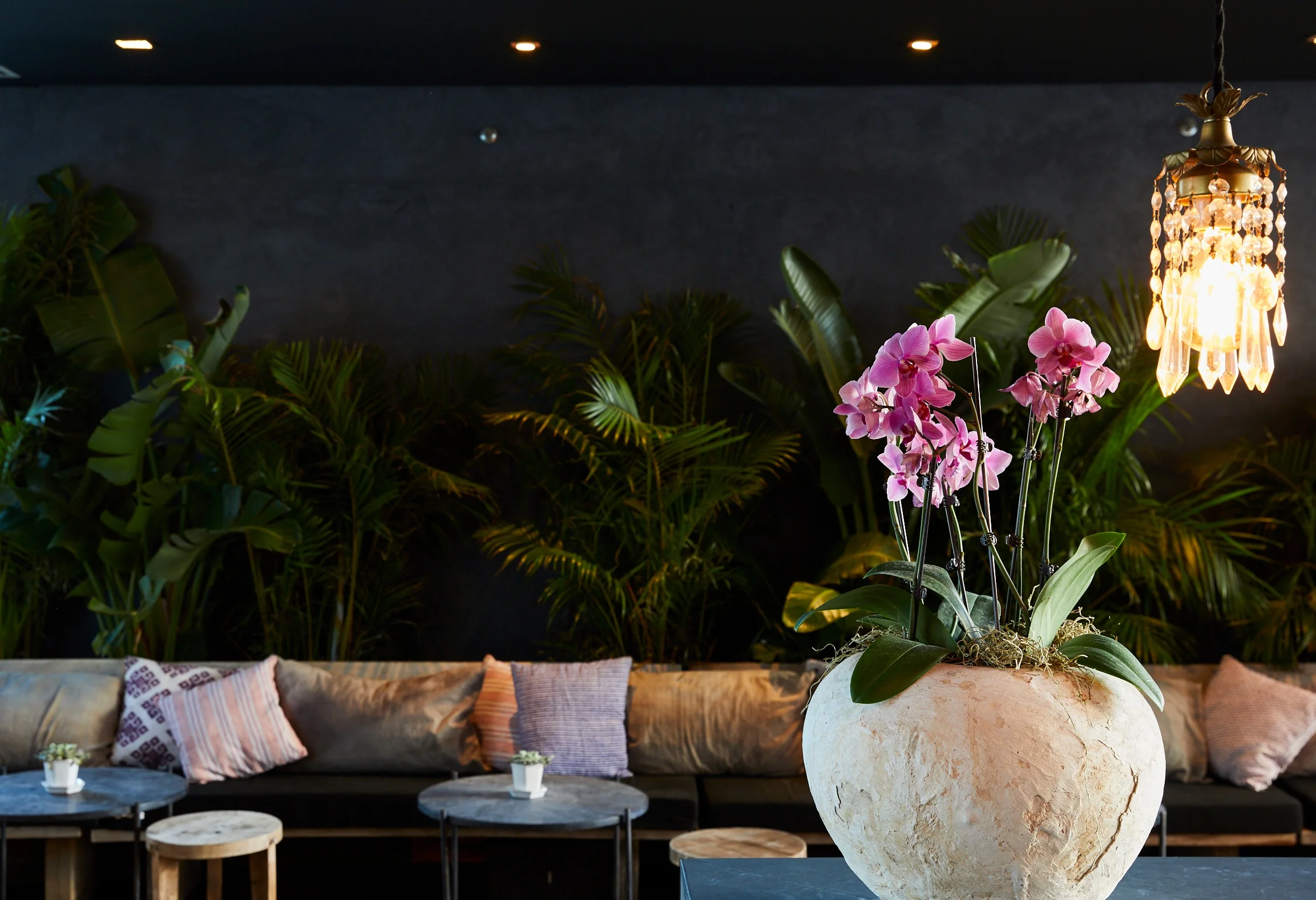 THE JUNGLE BAR WITH WOOD BENCHES, STOOLS AND MARBLE TABLES DESIGNED AND IMPORTED FROM TULUM.