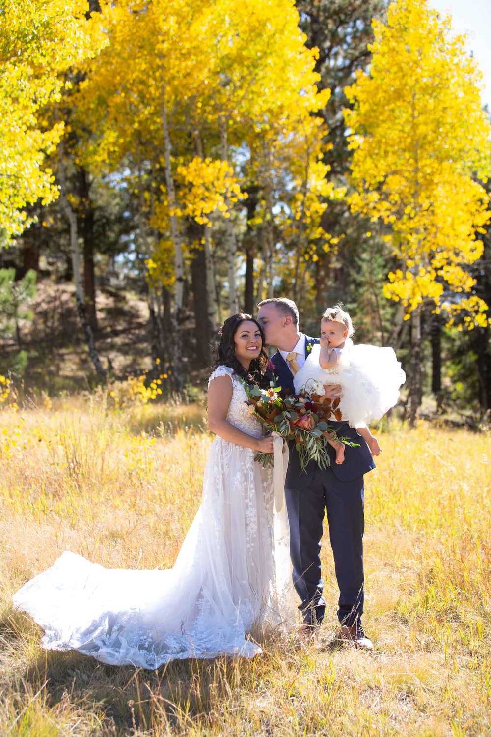 Bride, Groom and flower girl daughter at Deer Creek Valley Ranch in the yellow fall aspens