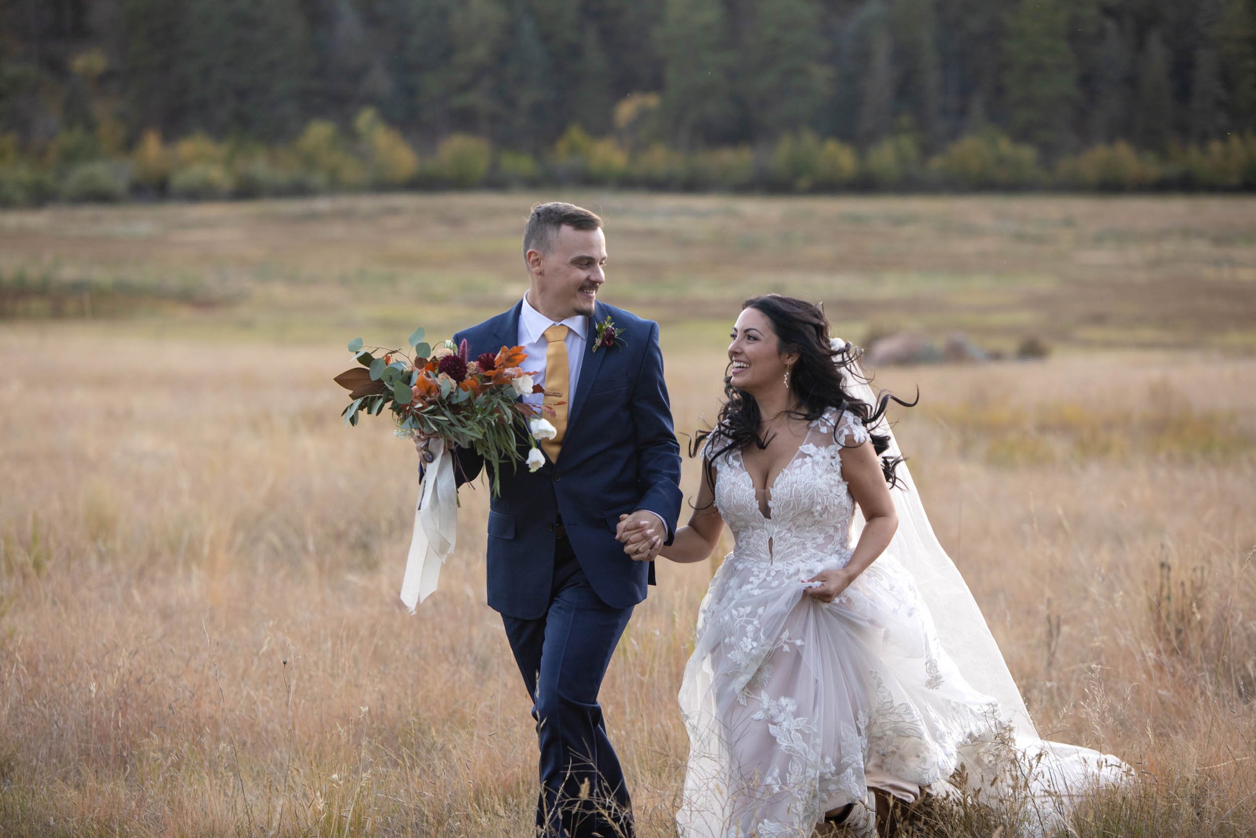 Bride in groom in the fields of at Deer Creek Valley Ranch at sunset