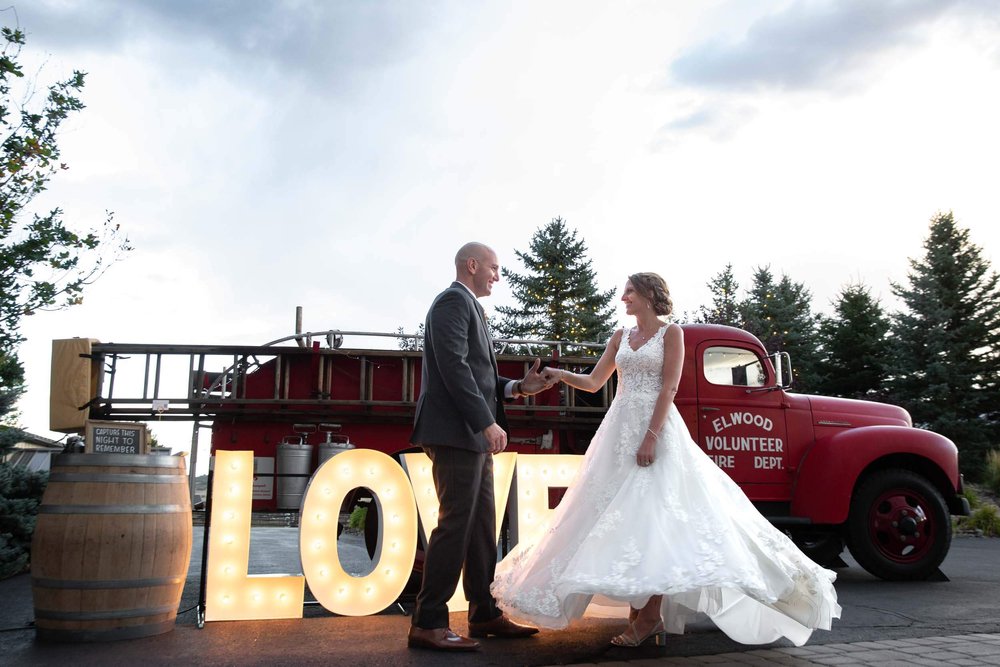 Bride and Groom in front of a vintage firetruck at Spruce Mountain Ranch