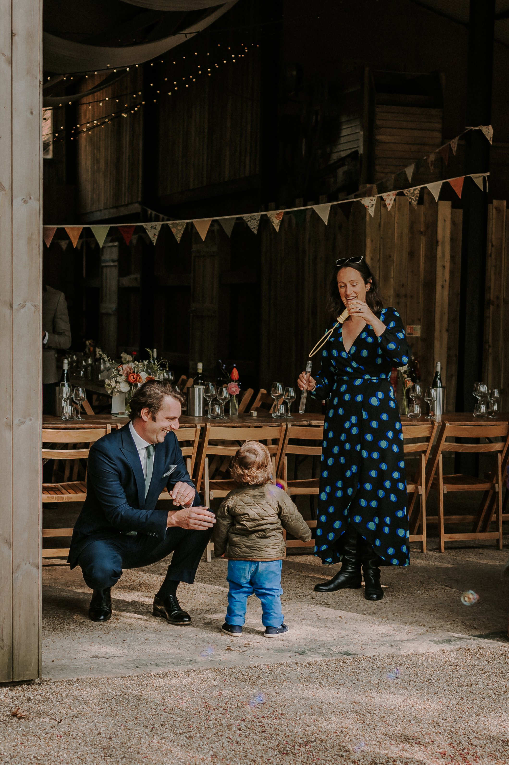 A Mother and Father Blow Bubbles for their Child during a Wedding Reception at Happy Valley Norfolk