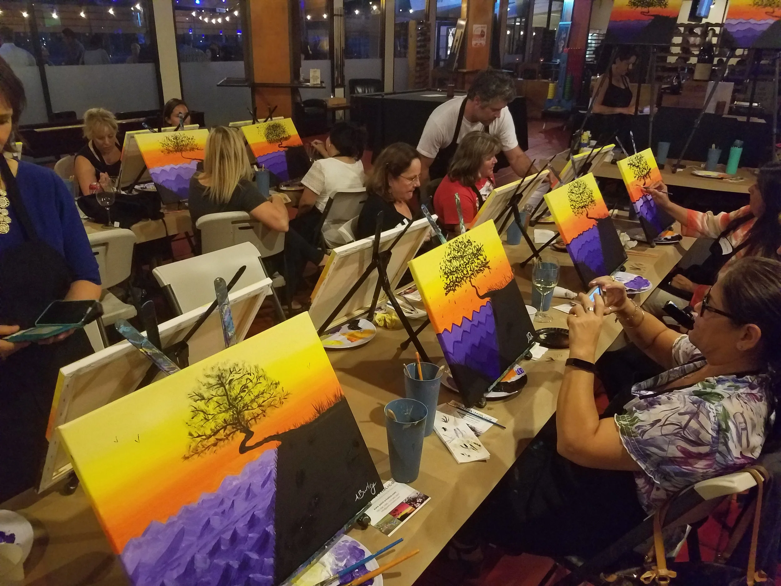Attendees make the final details on their paintings.
