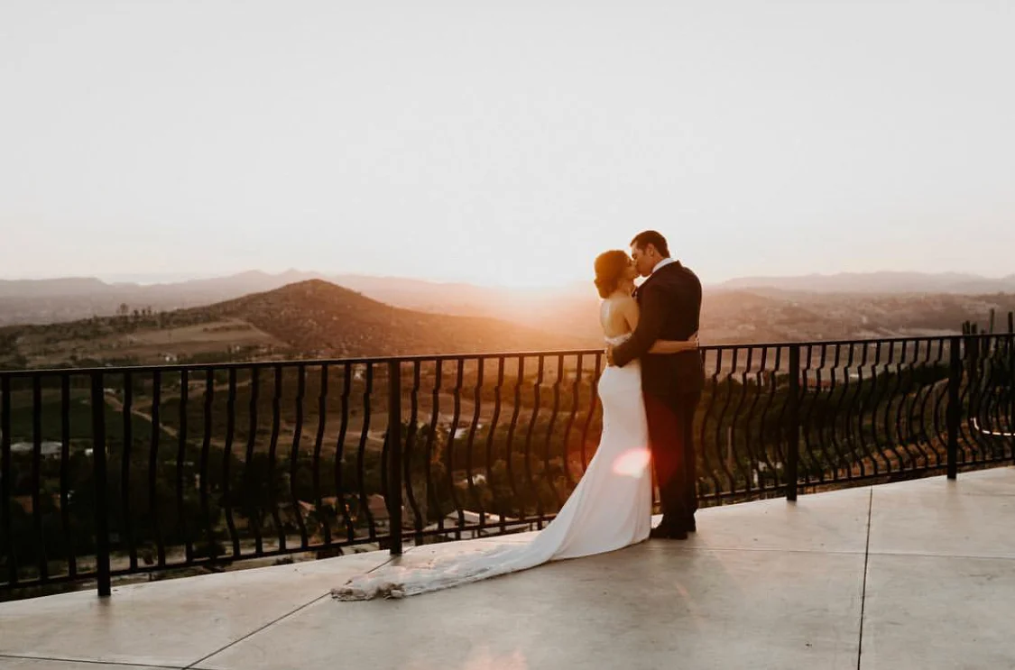 Bride and groom kissing in sunset