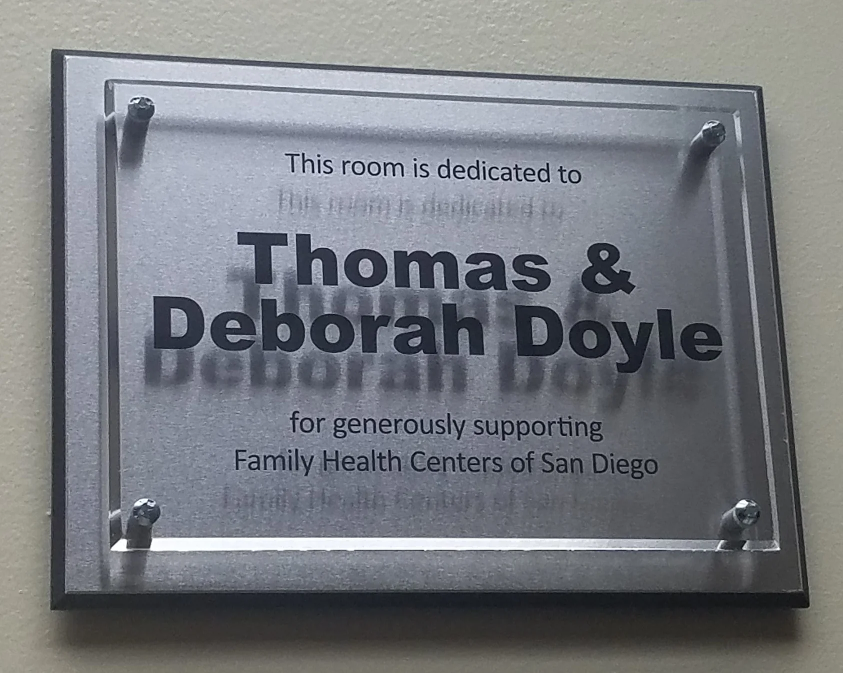 Wall plaque that reads “This room is dedicated to Thomas & Deborah Doyle for generously supporting Family Health Centers of San Diego.”