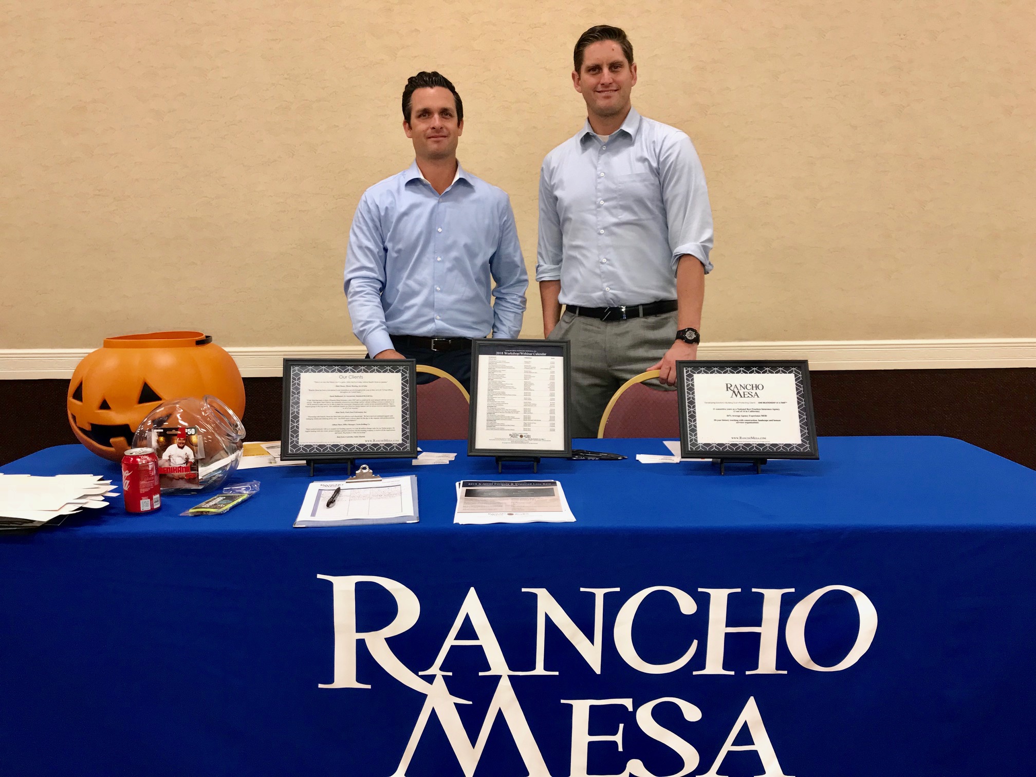 Kevin Howard and Andy Robert standing behind a table with a "Rancho Mesa" logo on the front.