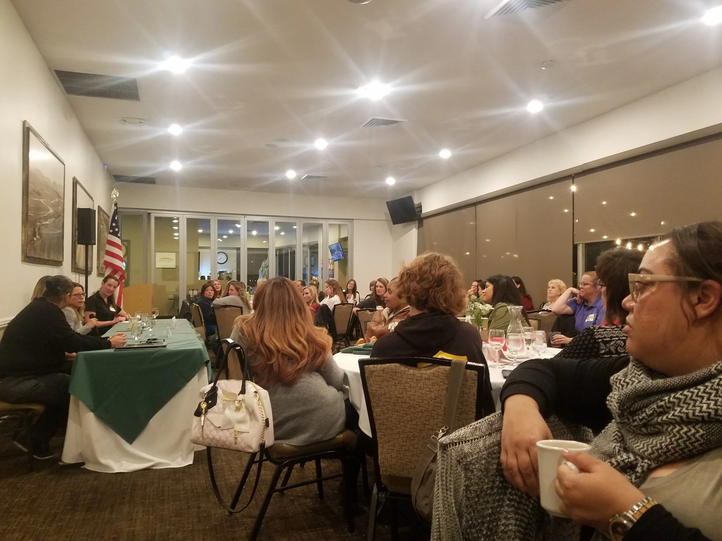 Banquet room full of women sitting at tables.