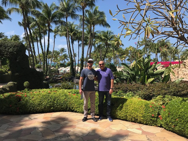 Drew and Dave Garcia smiling in a tropical setting