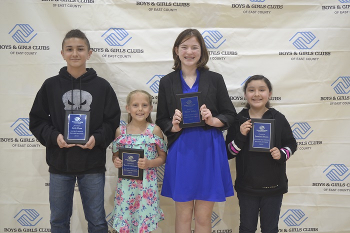 four boys and girls holding up their award plaques and smiling.