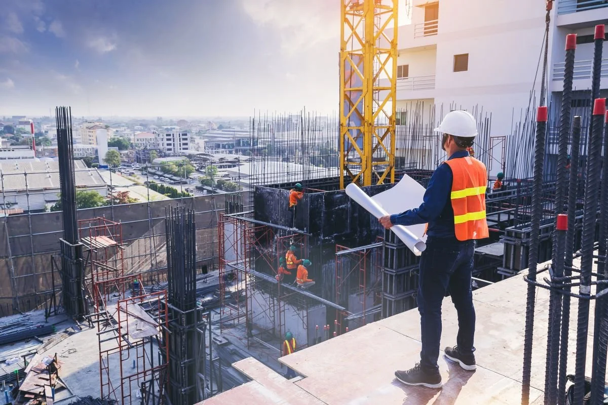 Construction worker inspecting building project while holding papers.jpg