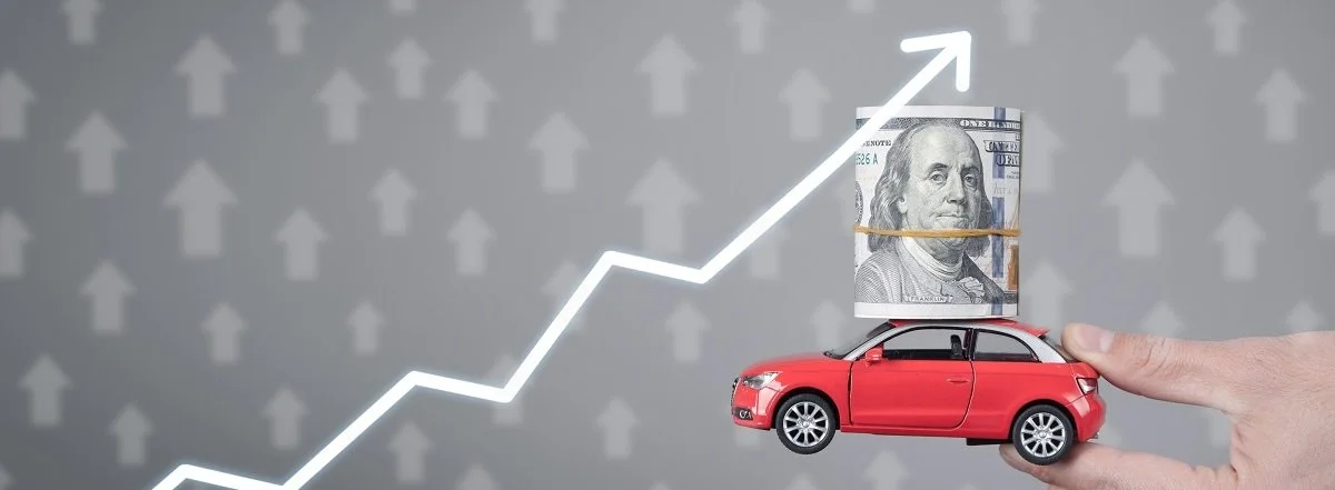 Hand holding car and money with growing arrows (Cropped).jpg