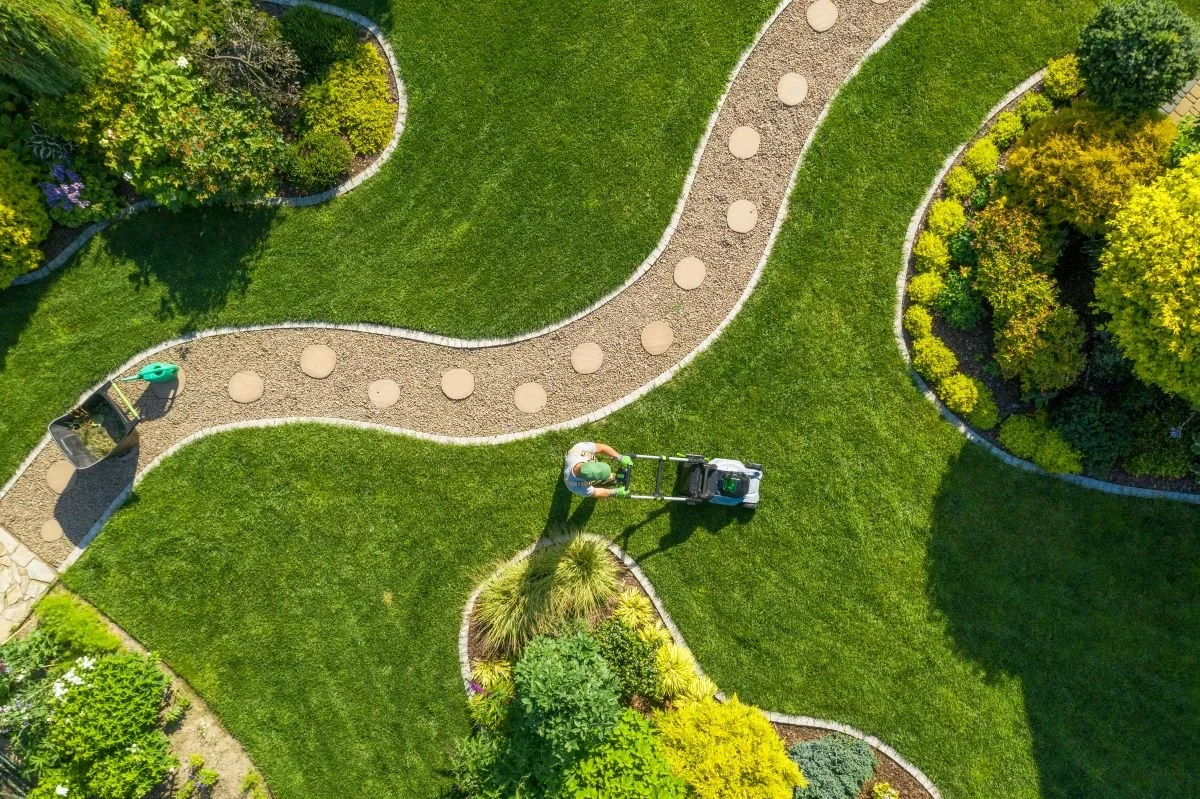 Landscaper mowing lawn in large garden.jpg