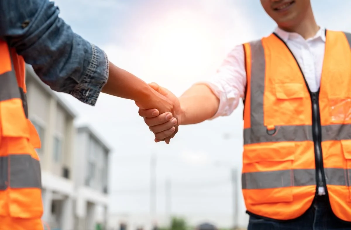 Construction workers shaking hands outside.jpg
