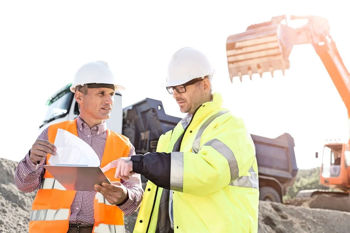 Engineers discussing over documents at construction site.jpg