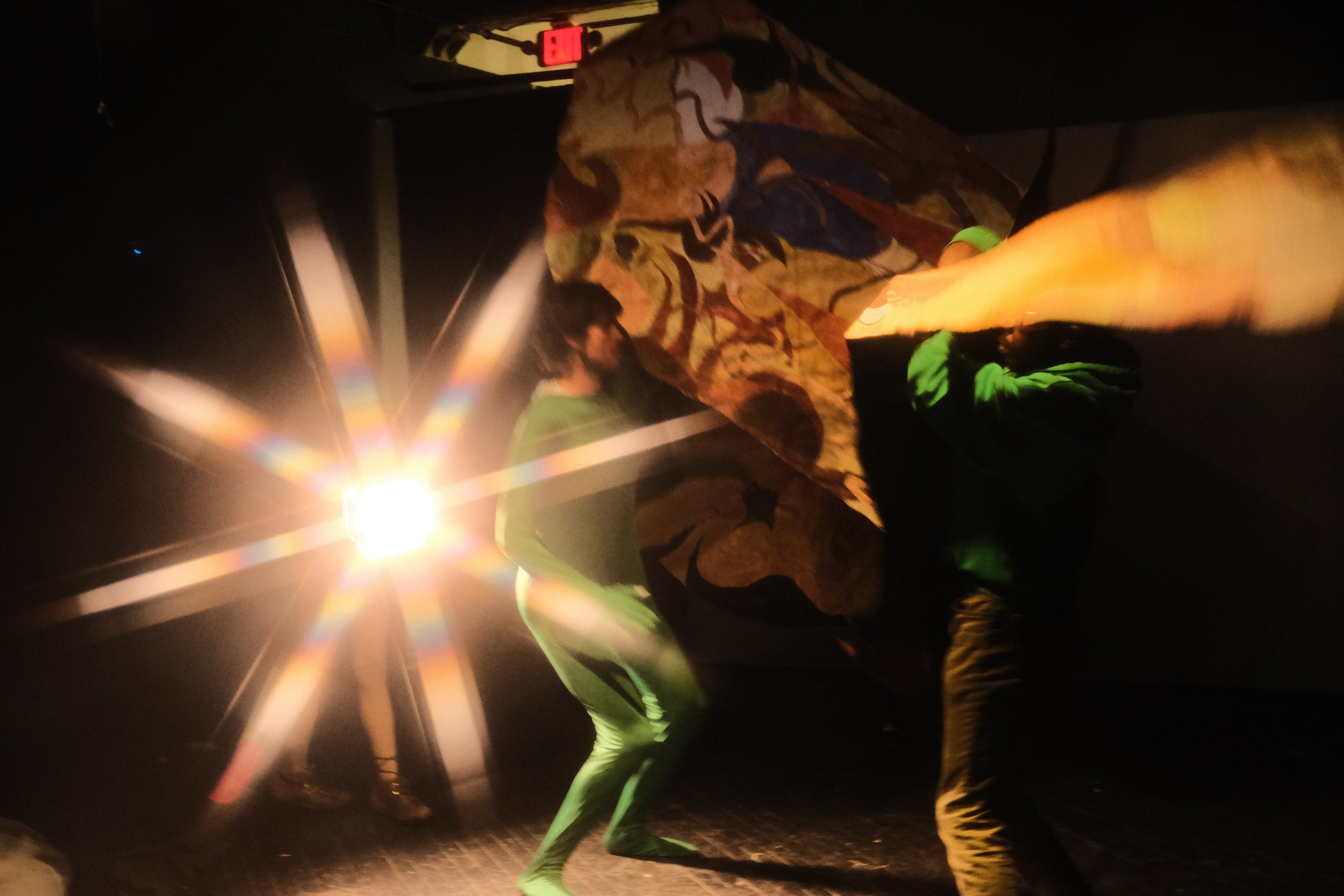  Live performance with video / performance still / approx. 30 min / 2022  This scene is the transition between the narrator Mudwig’s monologue and the opening of a portal to the Celestial Realm, the Abode of the Goddess. Three dancers in green activa