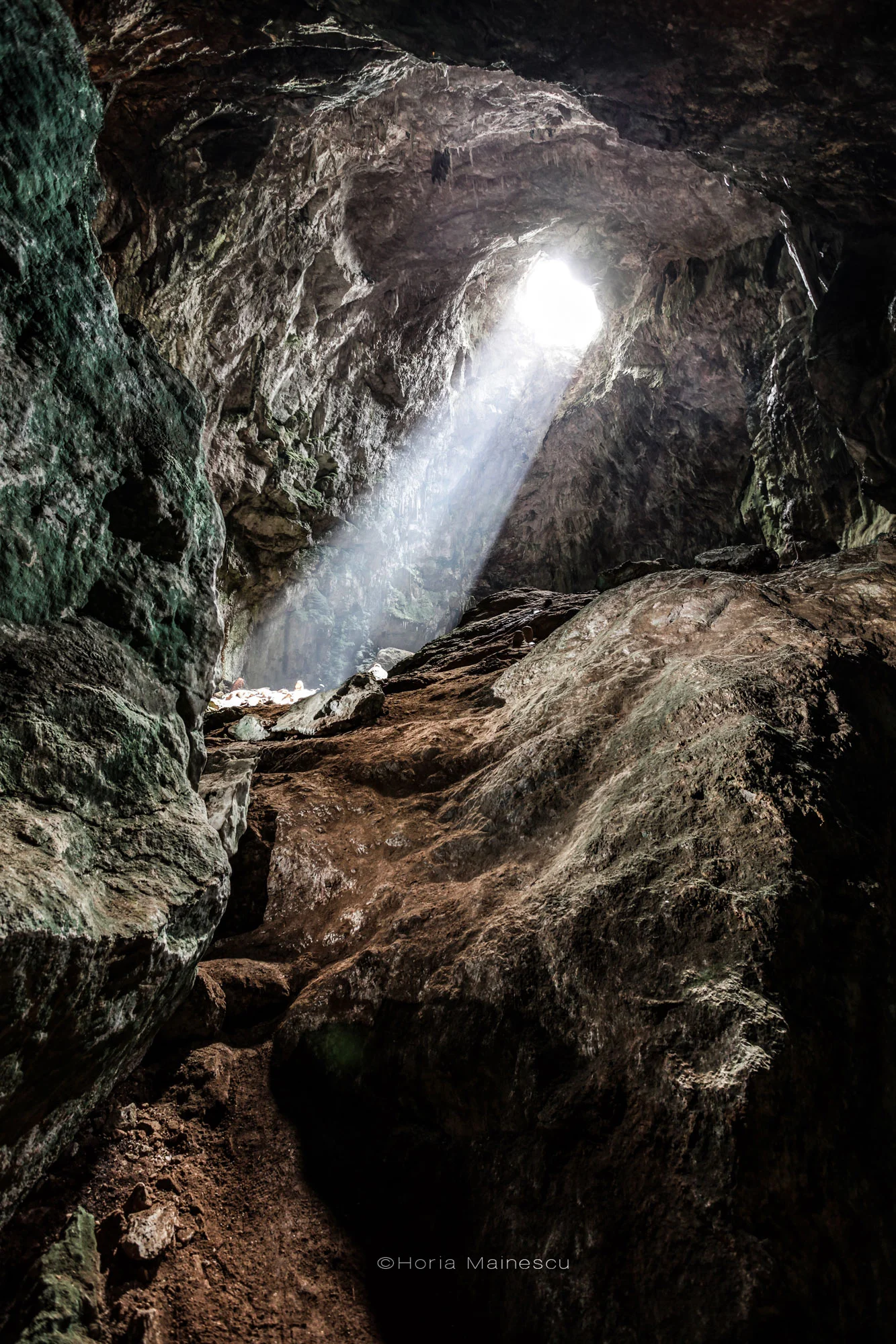 The cave is illuminated by natural light entering it through a hole located on the upper part.