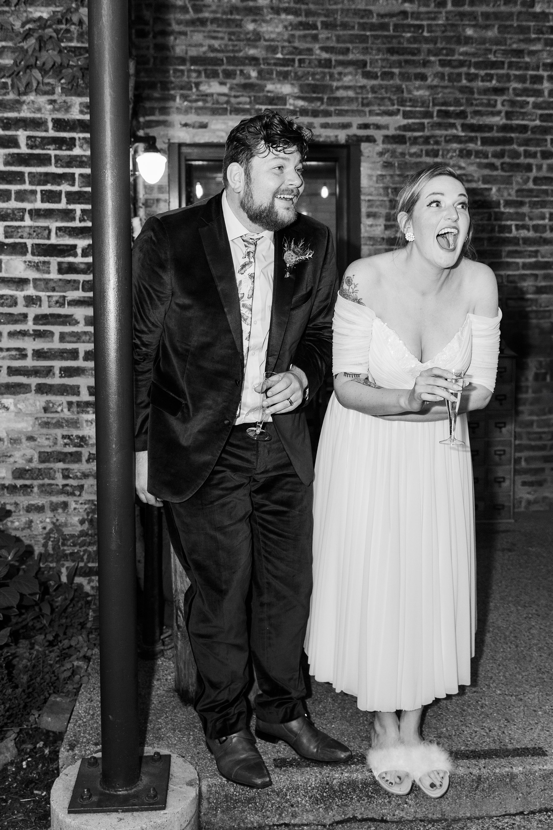  Direct flash candid of bride and groom laughing in reaction to speeches and nontraditional wedding at The Firehouse Chicago.  