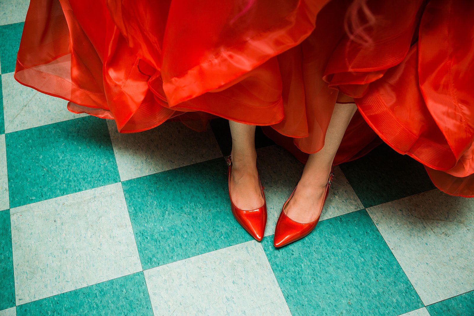  detail of Bride’s nontraditional red wedding shoes on green tile floor at dim sum restaurant Furama in Chicago 