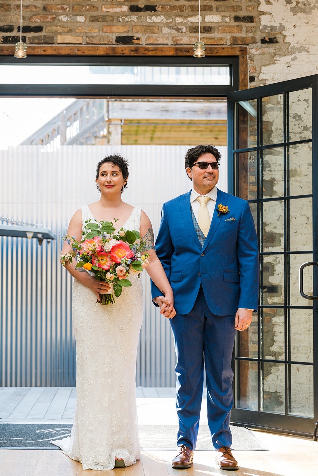  Candid, documentary photo of bride and groom entering their nontraditional Jewish and Venezuelan wedding ceremony in the round at The Joinery Chicago an Industrial loft wedding venue In Logan Square. 