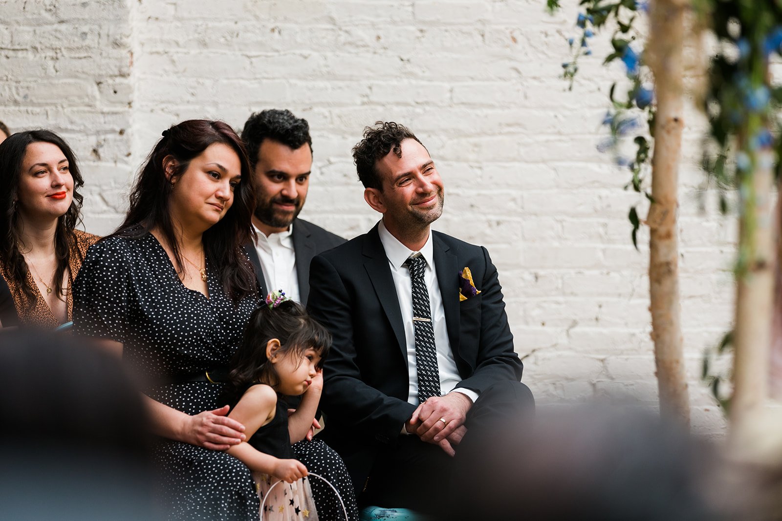  Candid, documentary photo of guests emotionally reacting to the bride and groom during their nontraditional Jewish and Venezuelan wedding ceremony in the round at The Joinery Chicago an Industrial loft wedding venue In Logan Square. 