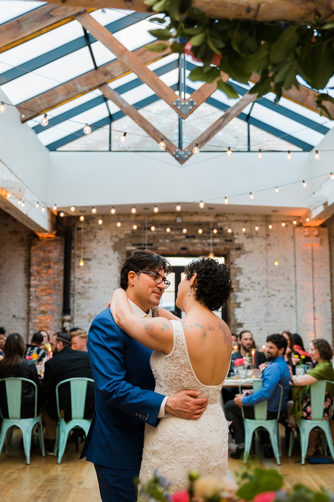  Documentary candid photo of bride and groom during first dance nontraditional Jewish and Venezuelan wedding at The Joinery Chicago an Industrial loft wedding venue In Logan Square.  