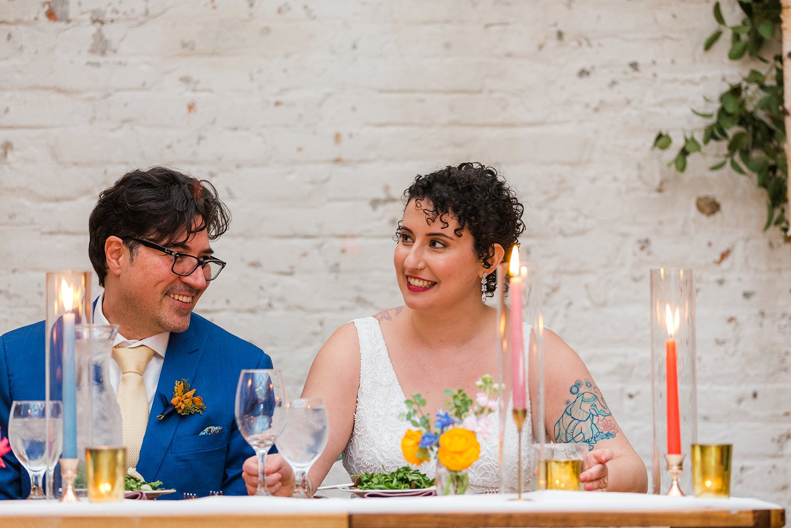  Documentary candid photo of bride and groom reacting to a toast during the reception at nontraditional Jewish and Venezuelan wedding at The Joinery Chicago an Industrial loft wedding venue In Logan Square.  