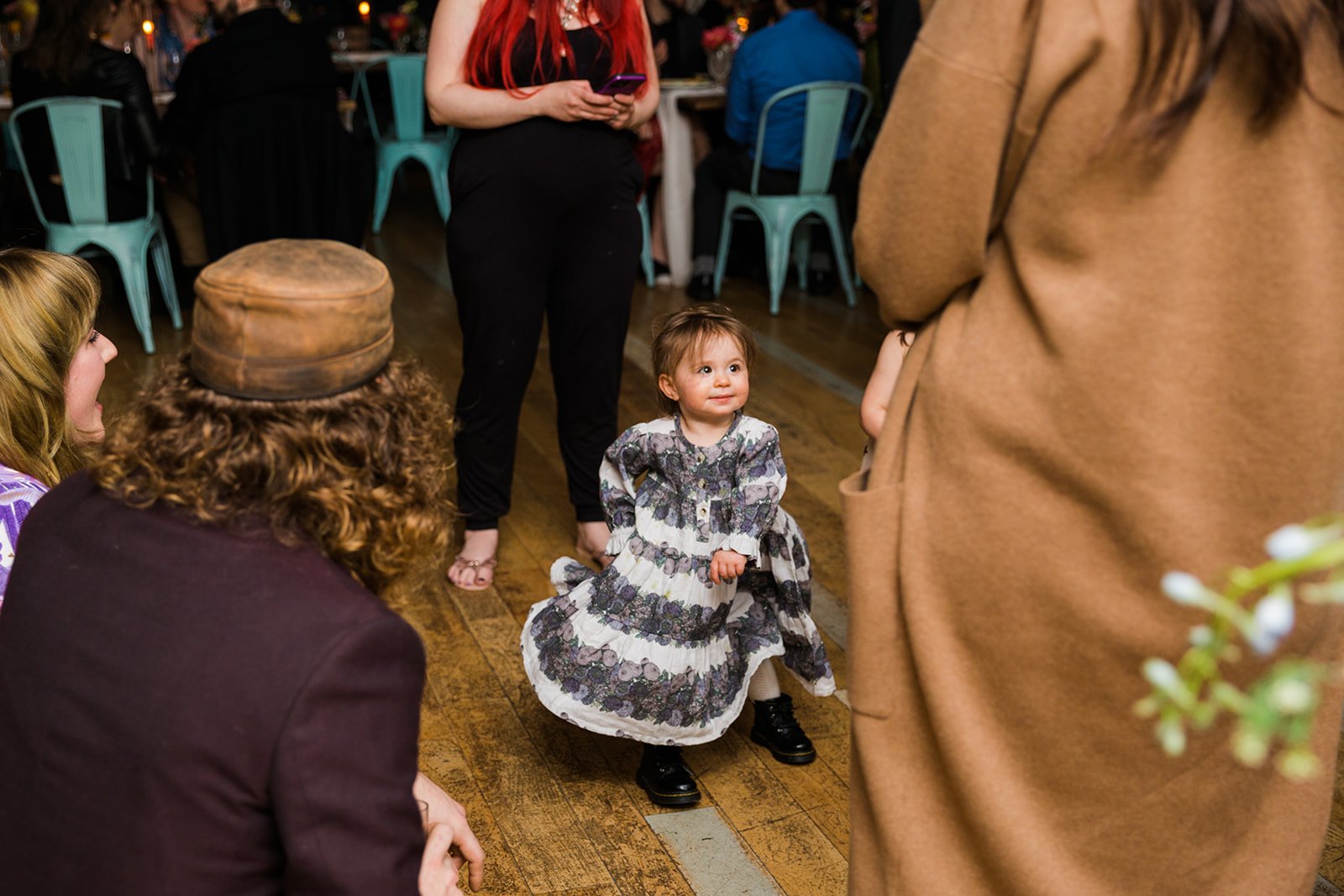  Documentary candid photo of flower girl dancing during the reception at nontraditional Jewish and Venezuelan wedding at The Joinery Chicago an Industrial loft wedding venue In Logan Square.  