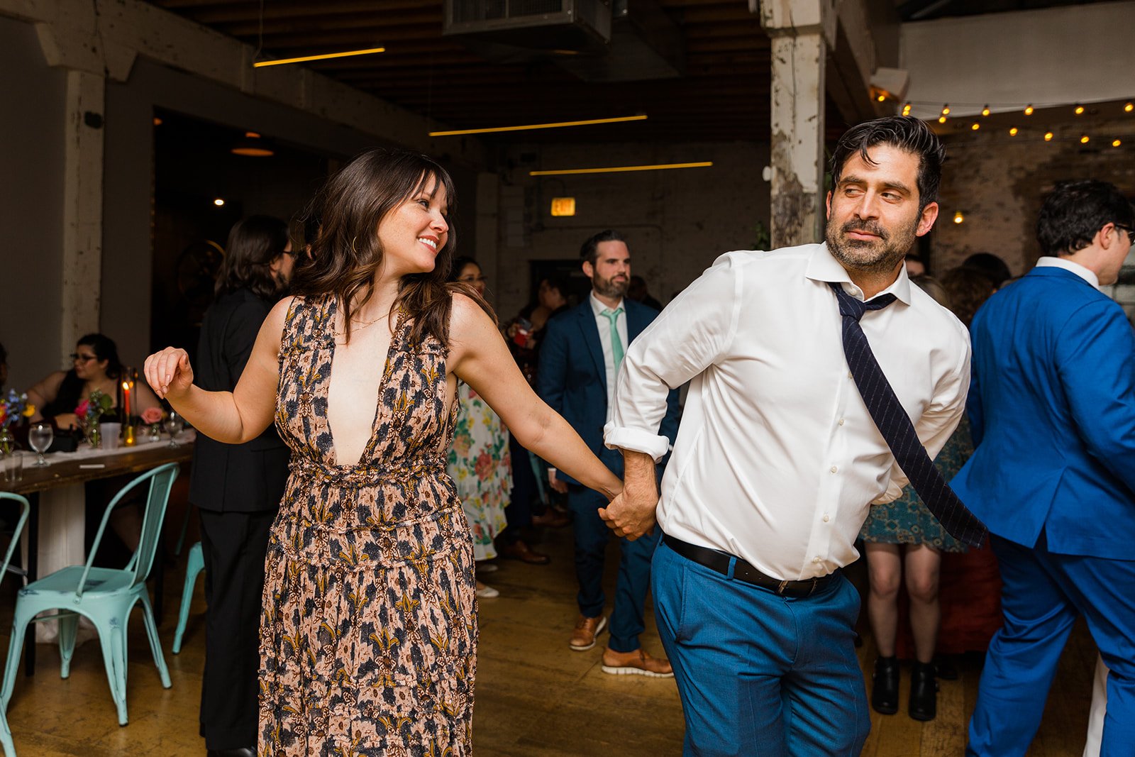  Documentary candid photo of a guests dancing at nontraditional Jewish and Venezuelan wedding at The Joinery Chicago an Industrial loft wedding venue In Logan Square.  